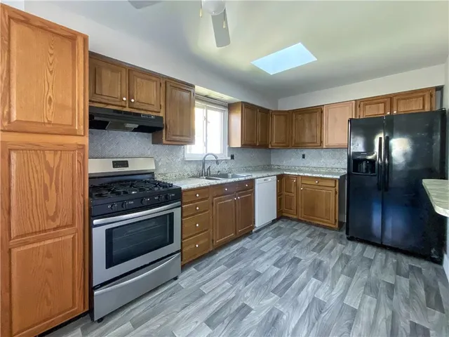 a kitchen with stainless steel appliances granite countertop a stove a sink dishwasher and a refrigerator