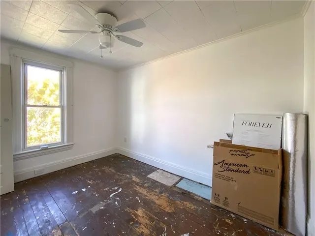 en empty room with windows and ceiling fan