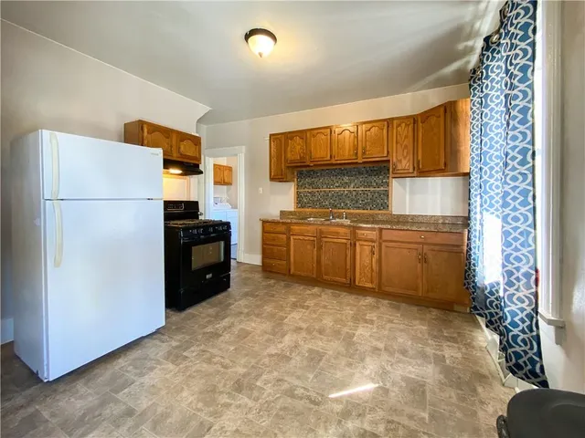 a kitchen with stainless steel appliances a refrigerator a sink a stove and cabinets