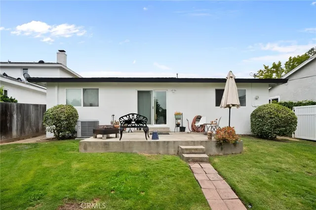 a view of backyard of house with outdoor seating and green space