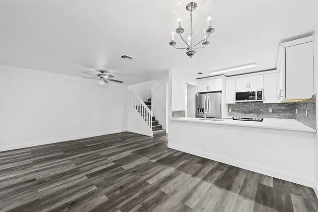 a view of a kitchen with sink and wooden floor