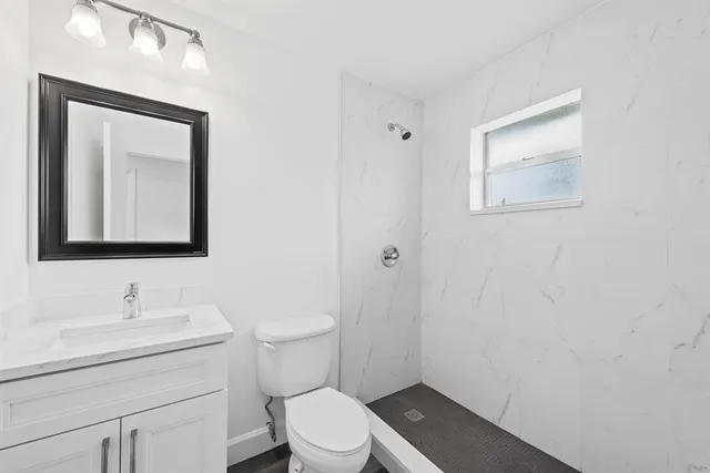 a bathroom with a toilet a sink and mirror