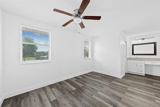 a view of empty room with wooden floor