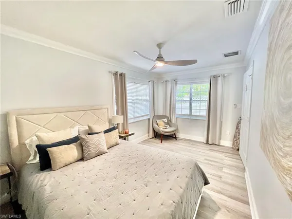 a spacious bedroom with a bed and large windows