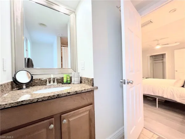 a en suite bathroom with a granite countertop double vanity and a mirror