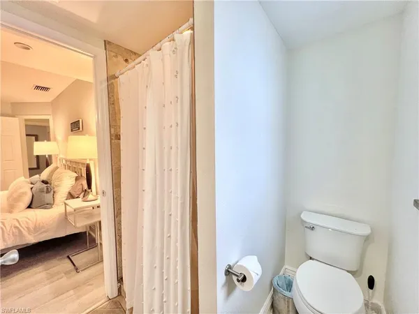 a bathroom with a toilet tub shower and a couch