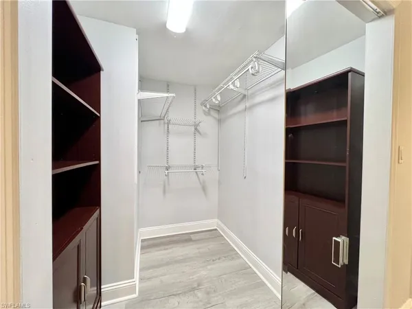 a view of walk in closet with empty racks