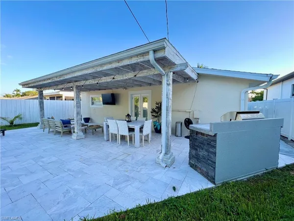 a view of a patio with table and chairs and a barbeque