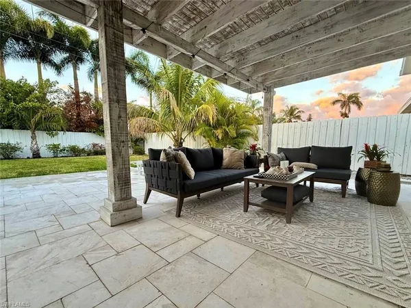 a view of a patio with table and chairs potted plants with palm trees