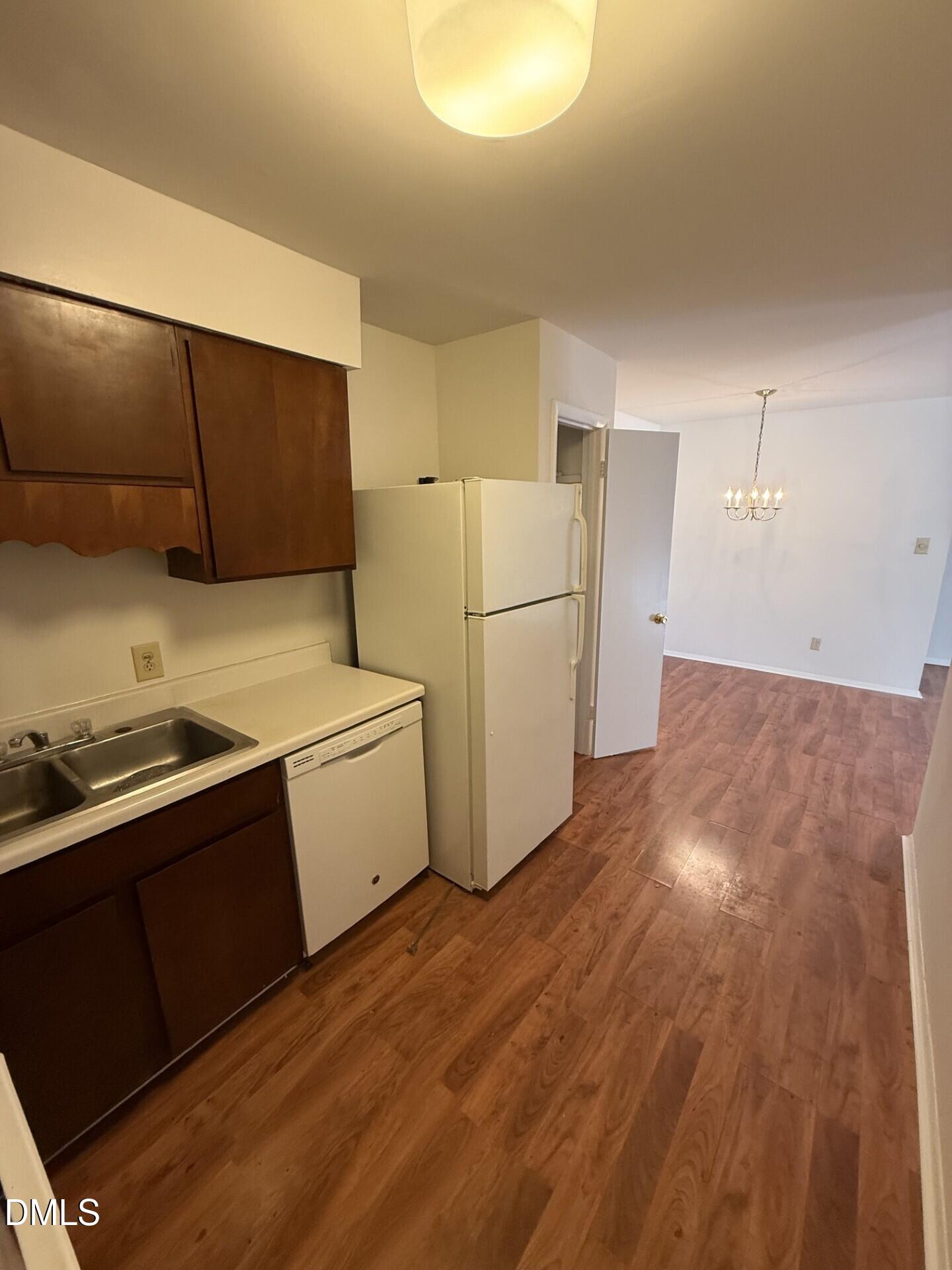 1299 Schaub Drive, Unit D Raleigh, NC 27606 - Photo 5 of 16 a kitchen with a refrigerator and a stove top oven