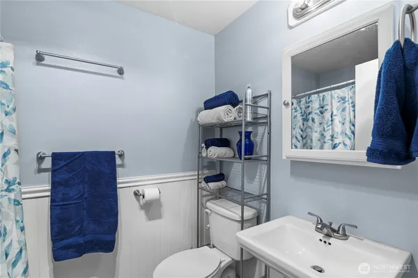 a bathroom with a toilet sink and mirror