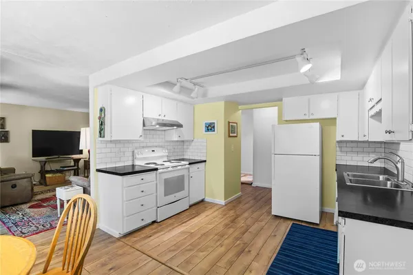 a kitchen with granite countertop a refrigerator stove top oven and sink