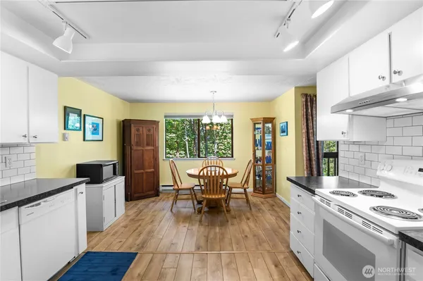 a kitchen with granite countertop a sink appliances and wooden floor