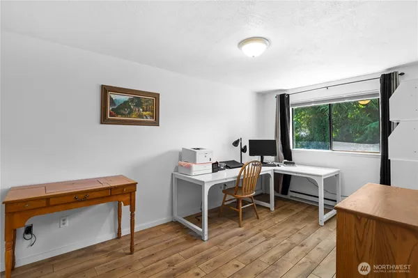 a view of a workspace with furniture and a window