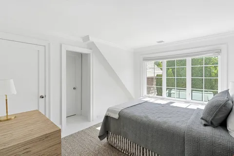 a bedroom with a bed and a large window