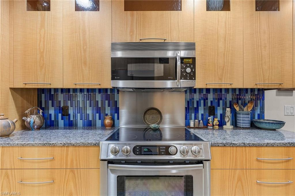 5677 Cove Circle Naples, FL 34119 - Photo 12 of 26 a kitchen with granite countertop stainless steel appliances and cabinets