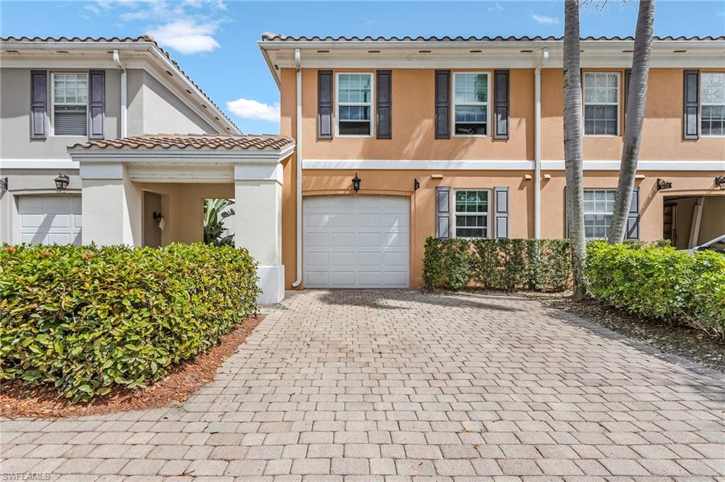 5677 Cove Circle Naples, FL 34119 - Photo 2 of 26 a front view of a house with a garden