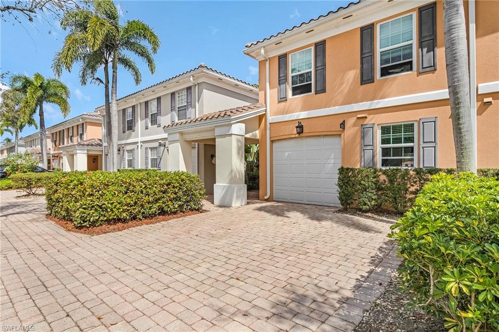 5677 Cove Circle Naples, FL 34119 - Photo 4 of 26 a front view of a house with a garden
