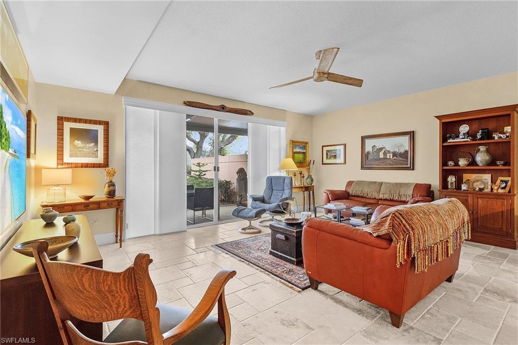 5677 Cove Circle Naples, FL 34119 - Photo 7 of 26 a living room with furniture and a large window