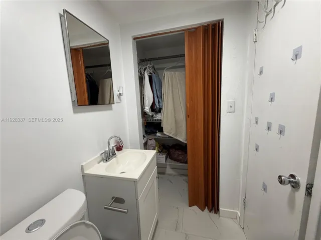 a bathroom with a sink a toilet and mirror