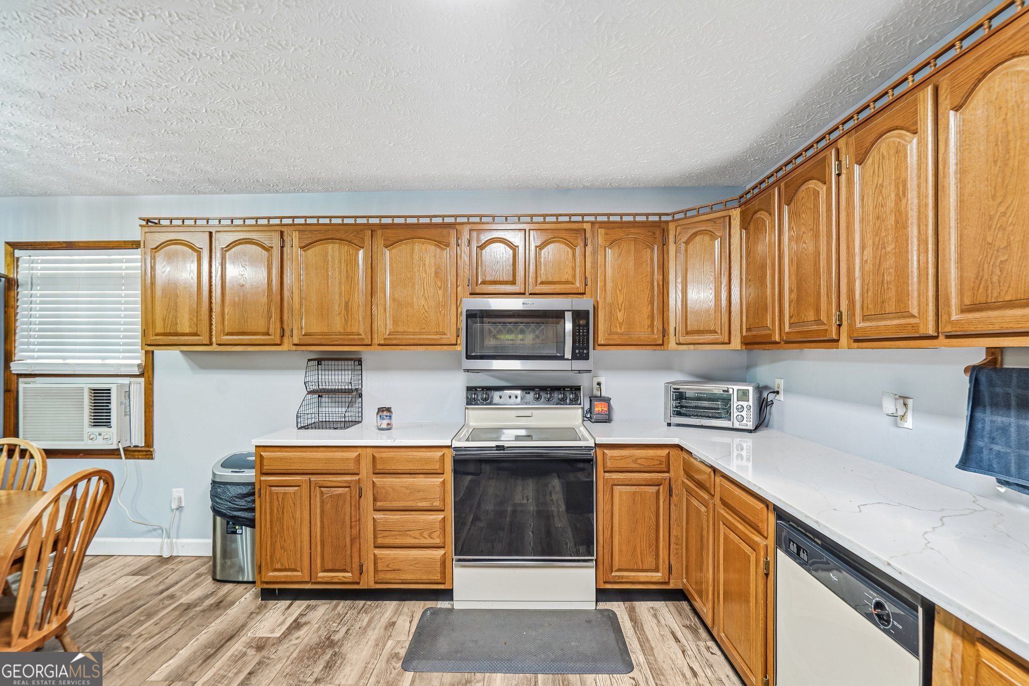 241 Busbin Road Fayetteville, GA 30215 - Photo 16 of 45 a kitchen with a sink a stove cabinets and a wooden floor