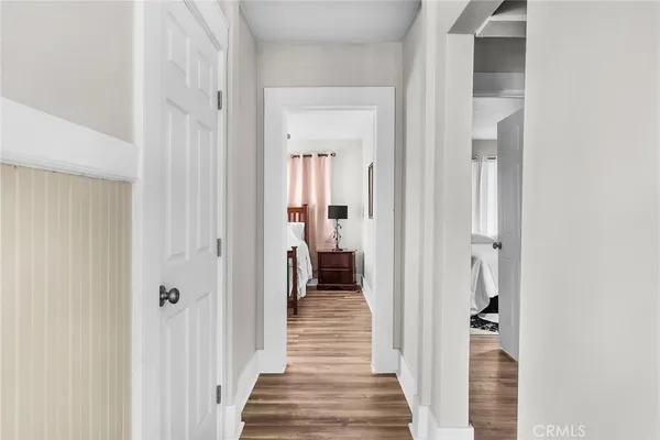 a view of a hallway with wooden floor and closet