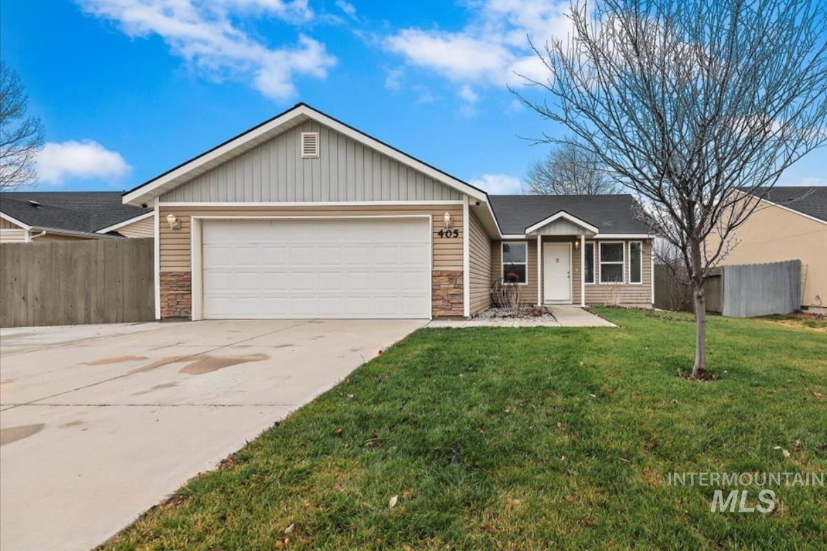 Ranch-style house with stone siding, driveway, a garage, and board and batten siding