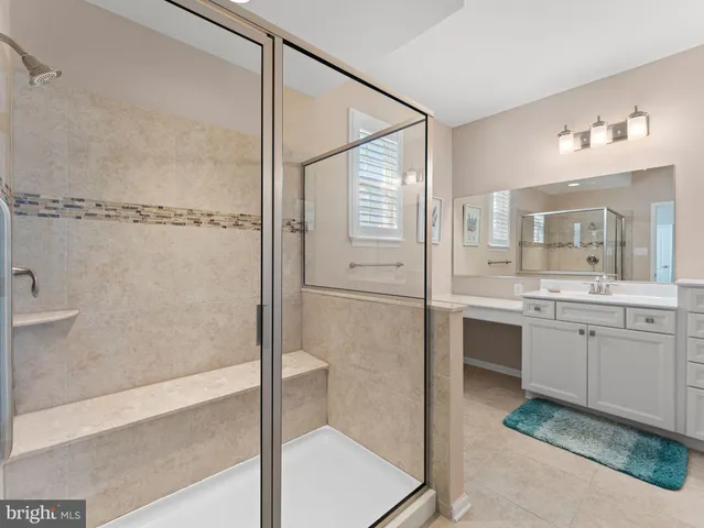 a bathroom with a granite countertop sink a mirror and a shower