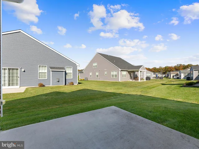 a view of big house with a big yard and potted plants