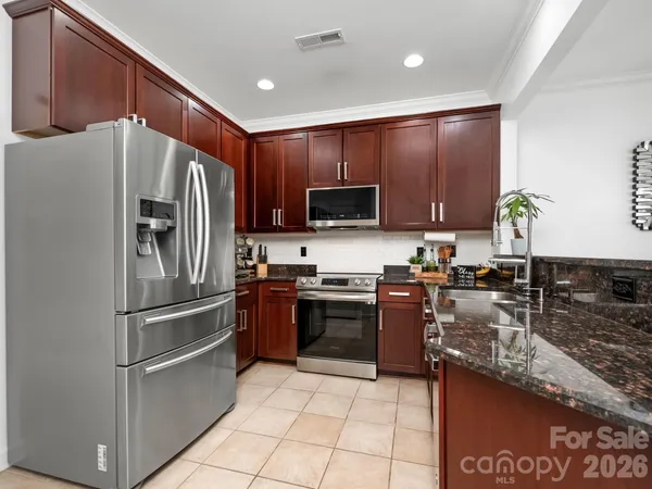 a kitchen with stainless steel appliances granite countertop a refrigerator sink and stove