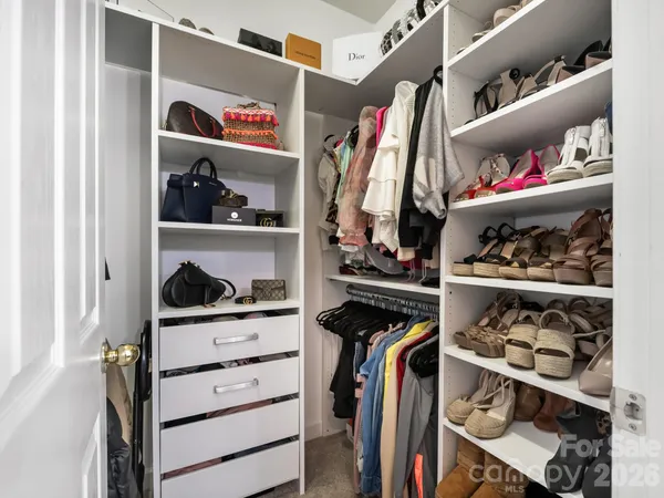a view of walk in closet with clothes and shoes