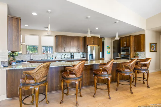 a dining area with stainless steel appliances kitchen island granite countertop a table and chairs