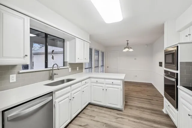 a kitchen with a sink cabinets and stainless steel appliances