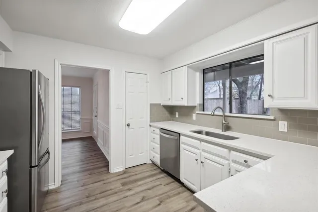 a kitchen with a sink cabinets stainless steel appliances and a window