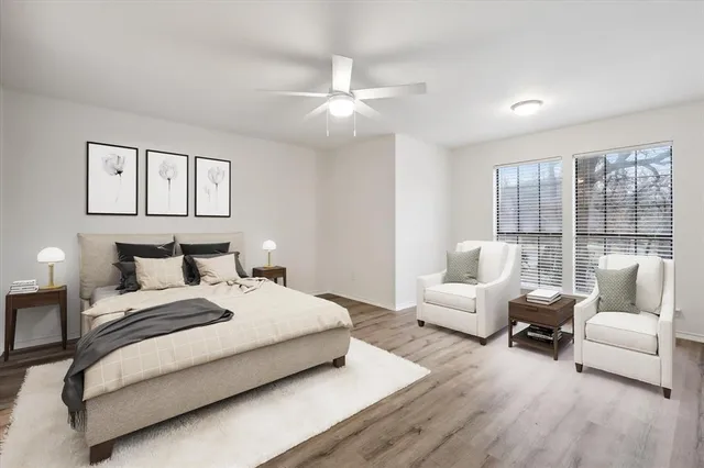 a bedroom with a large bed couch and windows