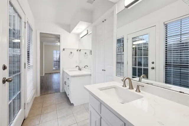 a bathroom with a sink vanity granite tub shower and a mirror