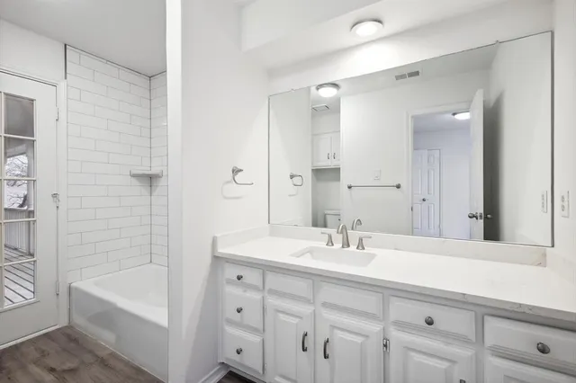 a bathroom with a tub sink and mirror
