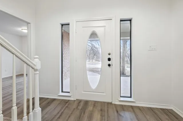 an entryway with wooden floor and cabinet