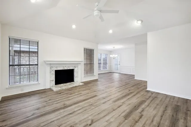 a view of empty room with wooden floor and fireplace