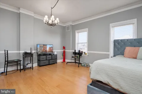 a bedroom with bed and a flat tv screen on dresser