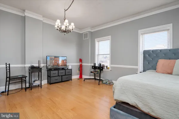 a bedroom with bed and a flat tv screen on dresser