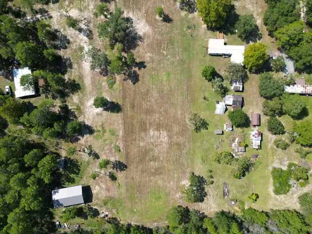an aerial view of a residential houses with yard