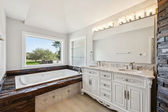 a bathroom with a granite countertop shower sink and mirror