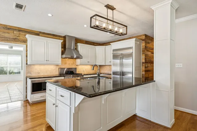 a kitchen with stainless steel appliances granite countertop a sink and refrigerator