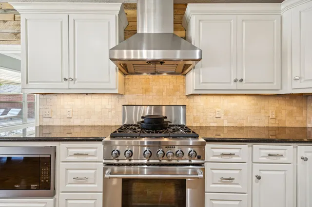 a stove top oven sitting inside of a kitchen