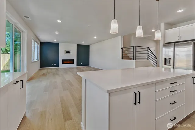 a large white kitchen with a large island oven a sink and a large window