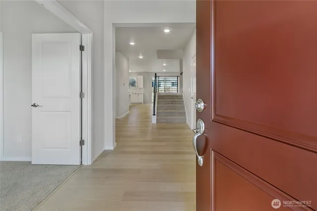 a view of a hallway with wooden floor and staircase