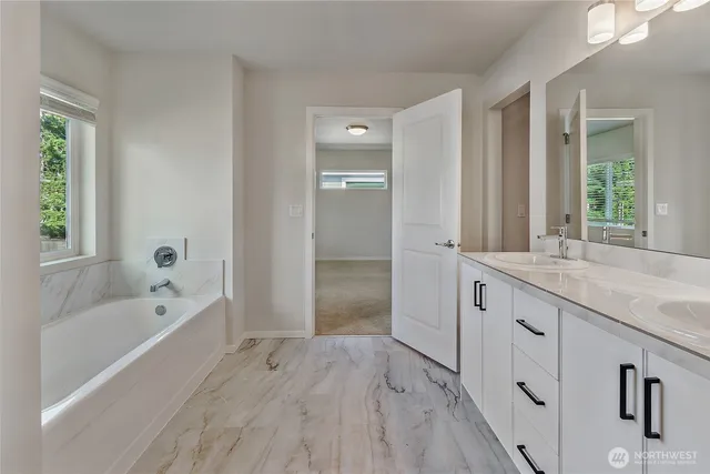 a bathroom with a granite countertop tub sink shower and mirror