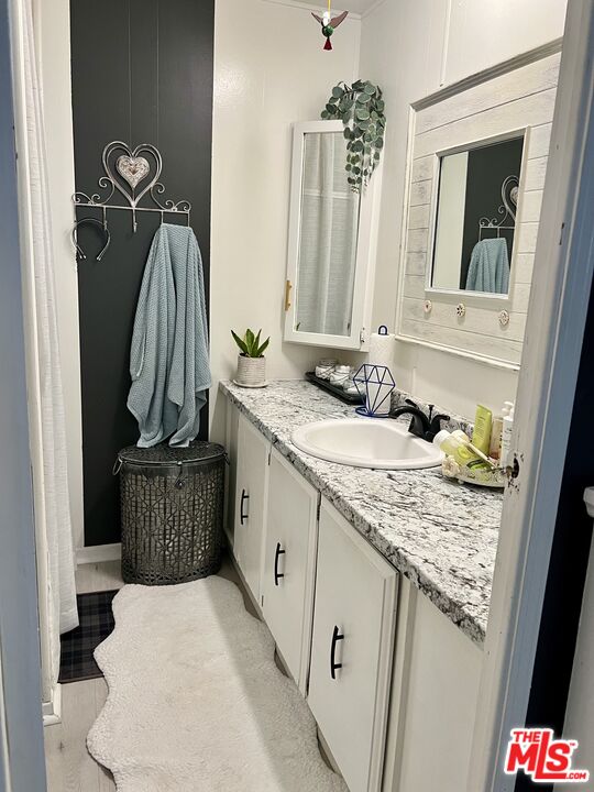 2744 West Rialto Avenue, Unit 49 Rialto, CA 92376 - Photo 16 of 40 a bathroom with a granite countertop sink and a mirror
