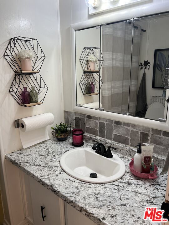2744 West Rialto Avenue, Unit 49 Rialto, CA 92376 - Photo 26 of 40 a bathroom with a granite countertop sink and a mirror